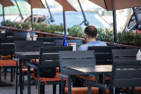 young man sitting in the street cafeの写真素材