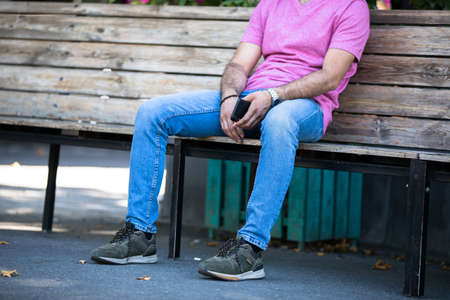 man hand phone sitting in the streetの写真素材