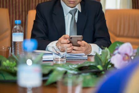 young man hand phone in conference hallの写真素材