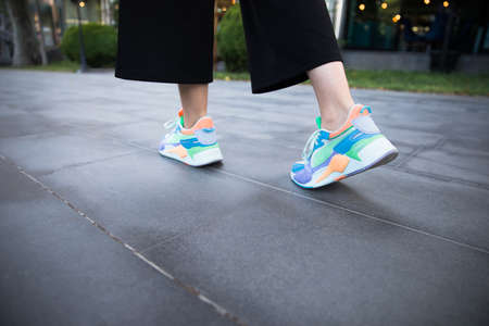 woman feet sport shoes walking in streetの写真素材