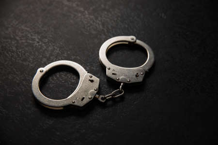 handcuffs on the black table backgroundの写真素材