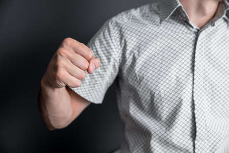 angry man fist on the dark wall backgroundの写真素材