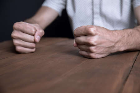 angry man fists on the table backgroundの写真素材