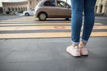 The young woman is crossing the street