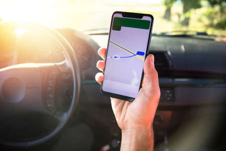 man hand phone and navigation in car