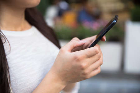 woman hand holding smart phone in street
