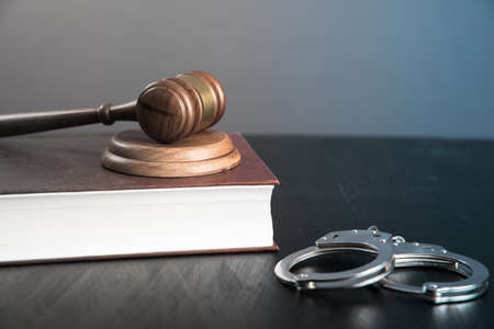 wooden judge on book with handcuffsの写真素材