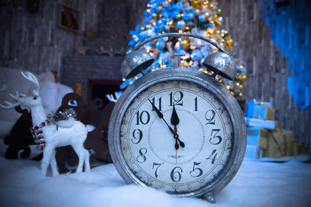 Christmas background. Alarm clock and christmas lights
