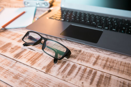 glasses with laptop and notepad on the tableの写真素材