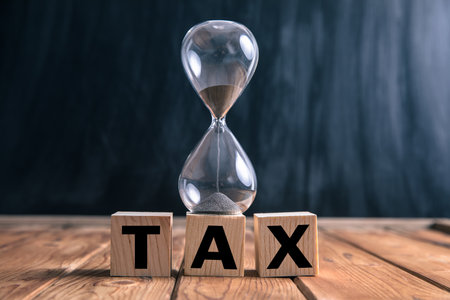 hourglass on tax on wooden cubes