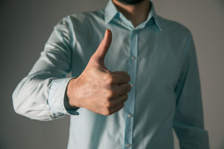 Business man showing ok, hand with thumb upの写真素材