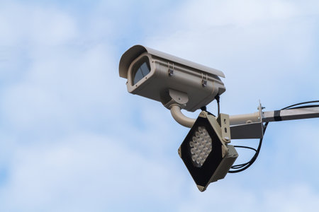 Gray security camera on blue sky backgroundの写真素材