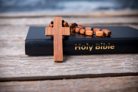 cross on Holy Bible on wooden tableの写真素材