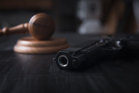 hammer gavel and gun on tableの写真素材