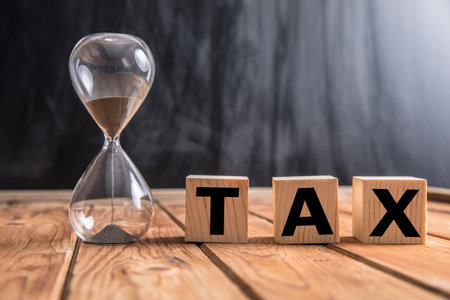 Tax word on wooden cubes with hourglass.の写真素材