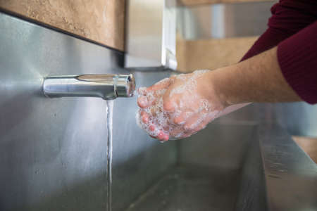man washes his hands with soapの写真素材