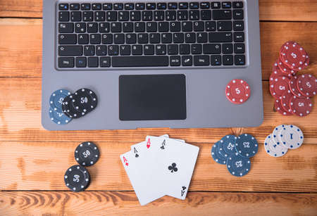 online poker with laptop and chips on tableの写真素材