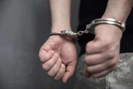 young man hand handcuffs in back