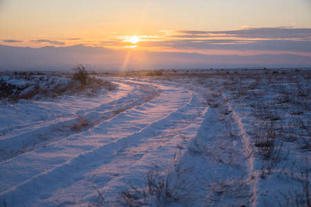 snowy landscape road at the sunsetの写真素材