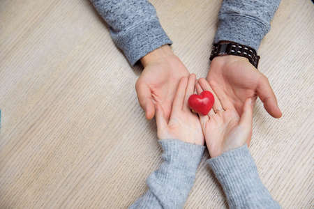 woman and man hand holding red heartの写真素材