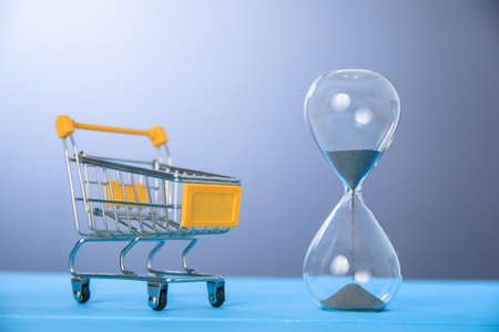Shopping cart and hourglass on the blue background