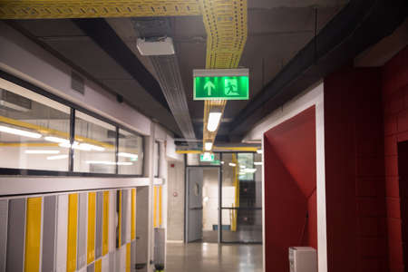 Illuminated green exit sign in hallway