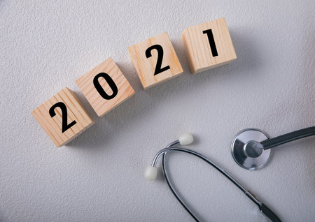 Wooden cubes with 2021 and a stethoscopeの写真素材