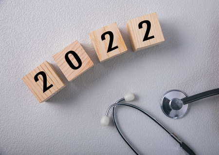Wooden cubes with 2021 and a stethoscopeの写真素材