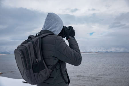 man holding camera in lake backgroundの写真素材
