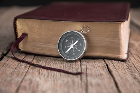 compass with Holy Bible on the wooden background
