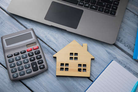 house model with calculator and notebook on tableの写真素材