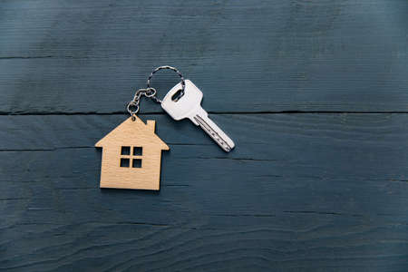 Key with trinket in shape of house on table