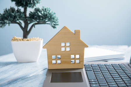 real estate, wooden house model on computer laptopの写真素材