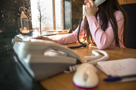 The young woman clerk is talking on the phoneの写真素材