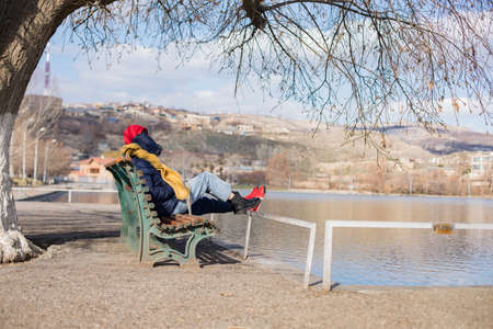 Young couple sitting under a tree at lakeの写真素材