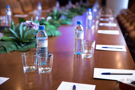 conference table with bottles of water and papers with pensの写真素材
