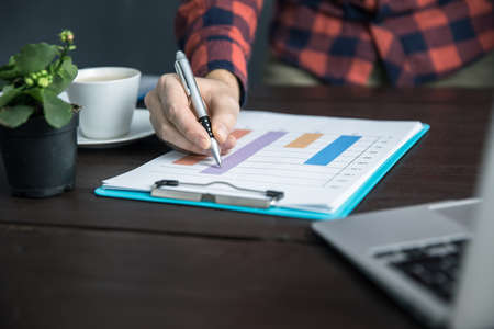 business man working computer with graph paper