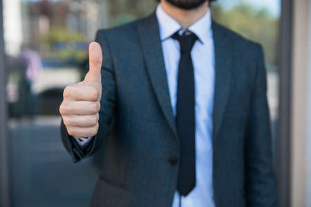 businessman standing in office and showing thumb upの写真素材