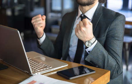 happy man working in computer sitting in cafeの写真素材