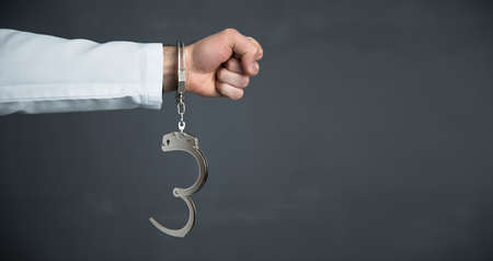 Handcuffs on arrested angry man hand
