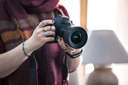 woman photographer holding camera in roomの写真素材