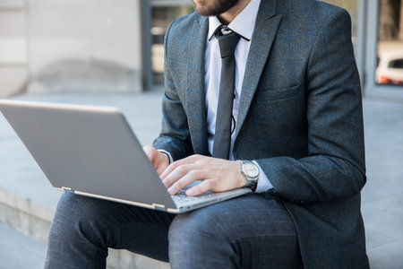 man working in notebook sitting in streetの写真素材