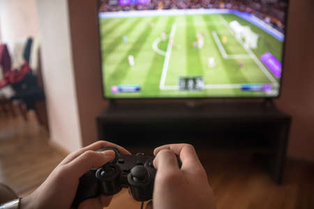 Hands Holding a Joystick Controller while playing a video games at home
