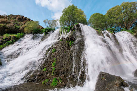Waterfall in deep rain forest under skyの写真素材