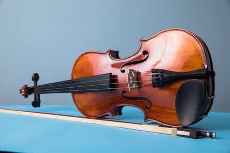 Classic violin with bow on the colored backgroundの写真素材