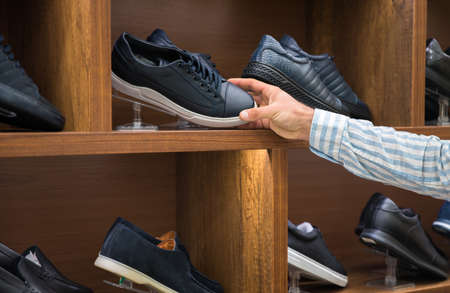 man holding brown shoes in shopの写真素材