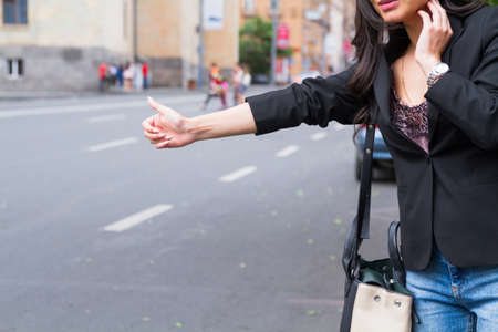 Portrait of business woman catching taxiの写真素材