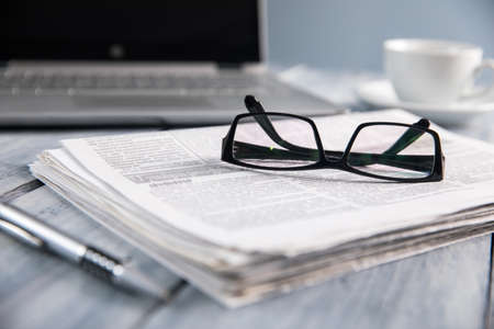 glasses on newspaper with notebook