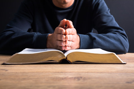prayer man hand on Bible on dark roomの写真素材