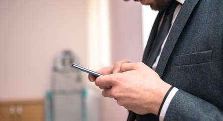 business man holding smart phone in office